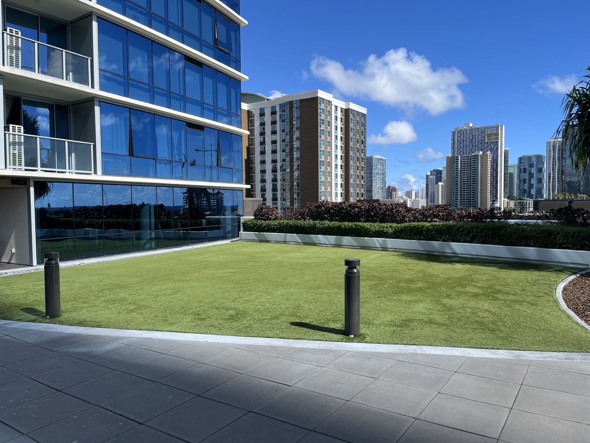 A modern building with a glass facade and a well-maintained lawn in front.